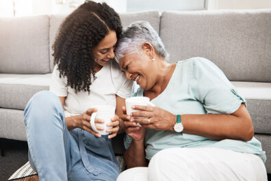 Mother daughter laughing while drinking coffee