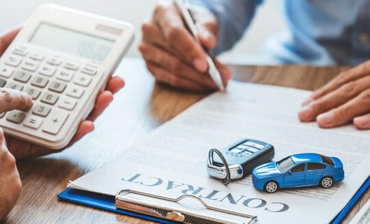 man signing automobile contract