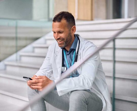 doctor sitting on stairs viewing mobile phone