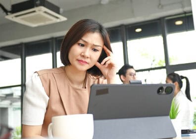 woman making a concerned face while looking at laptop