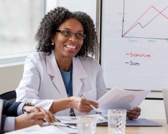 female doctor in board room with a chart displayed in background