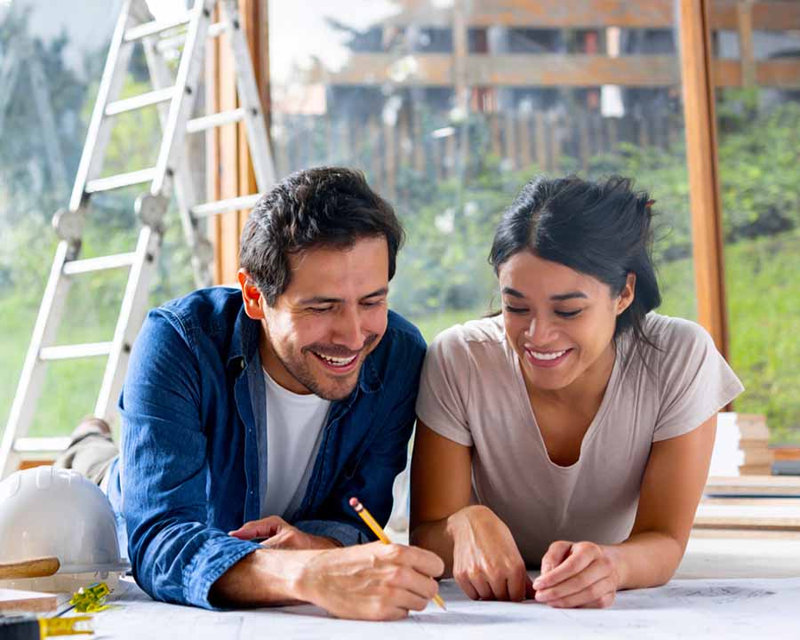 young couple reviewing building plans to prepare for a home improvement