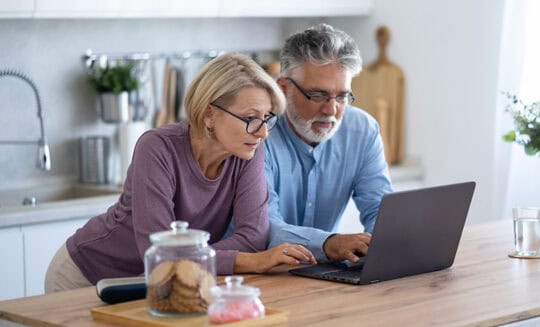 mature couple viewing laptop screen together