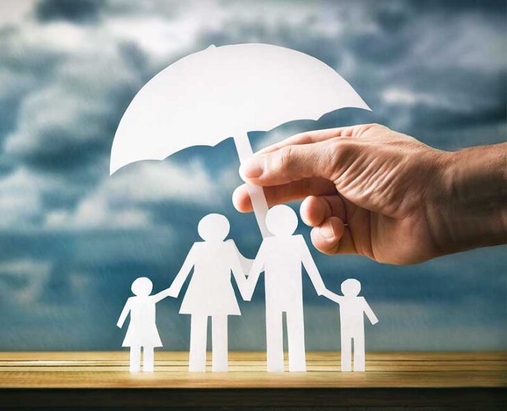 paper doll family holding hands and standing under umbrella
