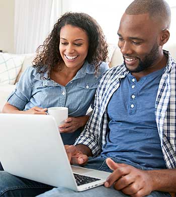 happy young couple at laptop together